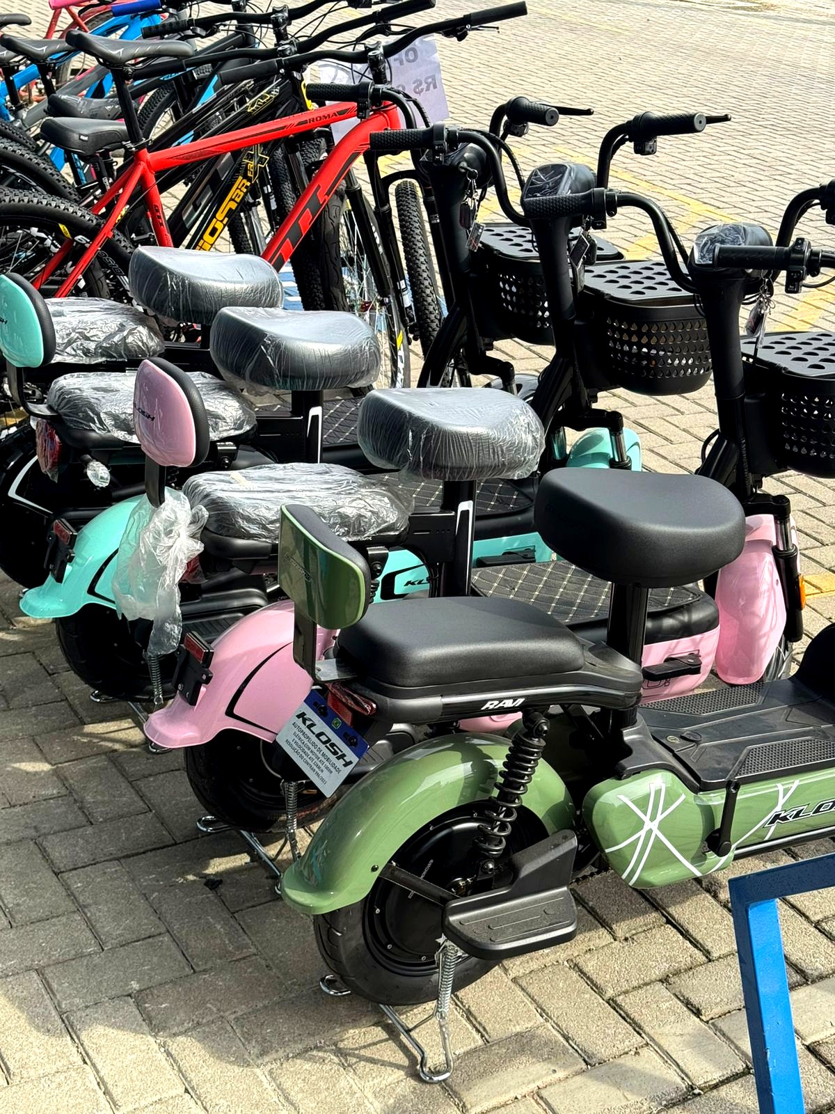 Scooters Klosh em exposição, cores variadas